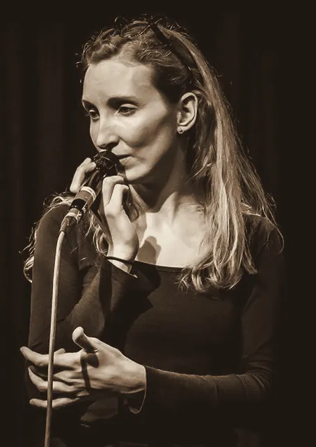 Sylvia at the microphone, eyes lowered
