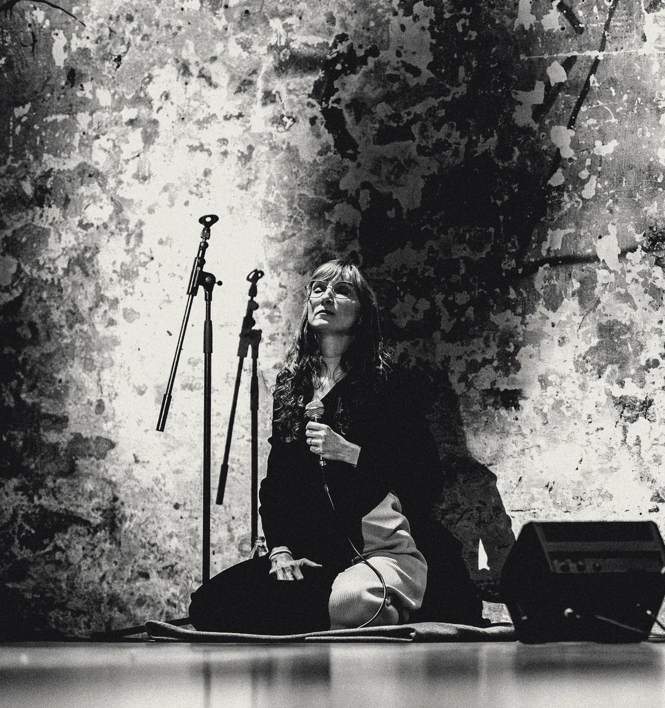 Sylvia kneeling on stage before a projected texture