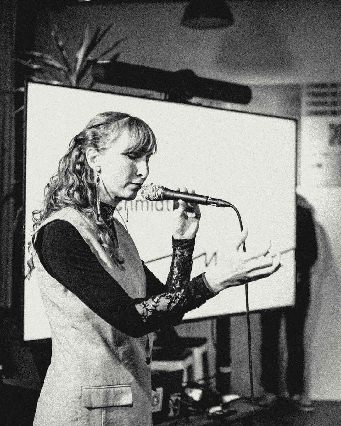 Sylvia singing at a microphone stand